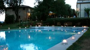 a swimming pool with candles in the middle of it at Villa Pieve De' Pitti in Terricciola