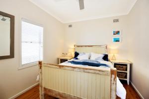 1 dormitorio con cama y ventana en Culburra Beachhouse, en Greenwell Point