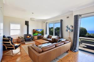 a living room with a couch and a fireplace at Culburra Beachhouse in Greenwell Point