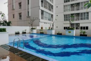 une grande piscine devant un immeuble dans l'établissement Best Price 2BR at Taman Melati Margonda Apartment By Travelio, à Depok