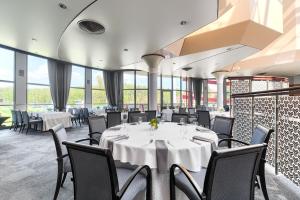 una sala da pranzo con tavoli, sedie e finestre di Hotel Olympic a Wronki