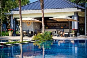 einen Pool mit Stühlen und Sonnenschirmen neben einem Resort in der Unterkunft Gaeavilla Resort in Jian