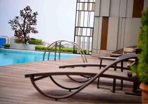 
a wooden bench sitting in front of a pool of water at Gumaya Tower Hotel in Semarang
