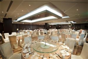 um grande salão de banquetes com mesas brancas e cadeiras brancas em Gaeavilla Resort em Jian