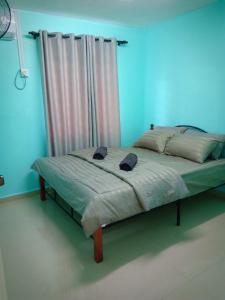 Cama en habitación con pared azul en AZURE SKY HOMESTAY KUALA SELANGOR en Kuala Selangor