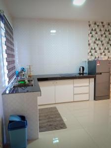 a kitchen with a counter and a sink and a refrigerator at AZURE SKY HOMESTAY KUALA SELANGOR in Kuala Selangor
