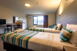 キングストンにあるKingston hotel Motelのベッド2台とキッチンが備わるホテルルームです。