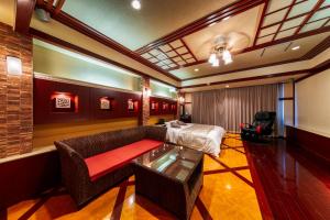 a living room with a couch and a table at Hotel Lotus Otsu (Adult Only) in Otsu