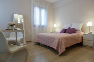 1 dormitorio con cama, mesa y espejo en LuimarVenue, en Pano Lefkara