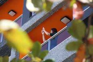 大漢村的住宿－海森威-七星潭電梯民宿，一位女士从建筑物的窗户望出去