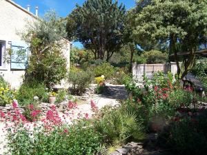 a garden with flowers and plants in front of a house at Les Florides in LʼIsle-sur-la-Sorgue