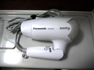 a white hair dryer with a cord plugged into it at Hotel Route-Inn Katori Sawara Ekimae in Katori