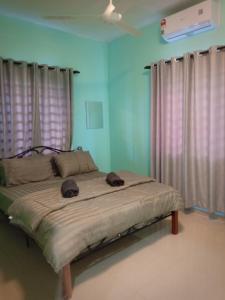 Un dormitorio con una cama con dos sombreros. en AZURE SKY HOMESTAY KUALA SELANGOR en Kuala Selangor