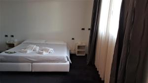 a bedroom with a white bedspread and white pillows at Hotel Delle Terme Di Venturina in Venturina Terme