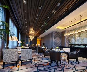 a restaurant with tables and chairs in a lobby at Wanda Realm Hotel Dongying in Dongying