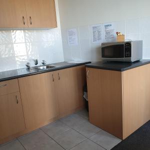 een keuken met een magnetron en een spoelbak bij Bamboo Motor Inn in Lakes Entrance