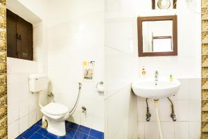 a bathroom with a toilet and a sink at Hotel Ashrey in Dehradun +26 photos