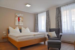 a hotel room with a bed and a chair at Bed Bike & Breakfast in Traismauer