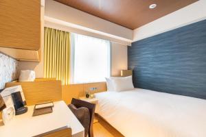Rúm í herbergi á Daiwa Roynet Hotel Nagoya Fushimi