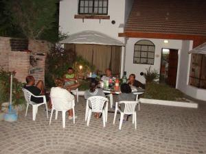 Un gruppo di persone seduti intorno a un tavolo in un cortile di Complejo Tehuelches a Puerto Madryn Altre 51 foto