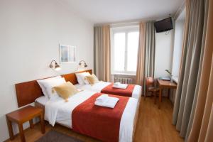 a hotel room with two beds and a television at Hotelli Helmi in Turku