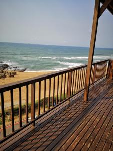 a wooden deck with a view of the beach at 21 Camarque in Umdloti