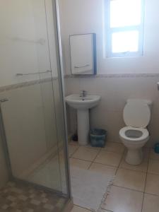 a bathroom with a toilet and a sink at 21 Camarque in Umdloti