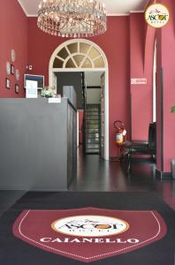 a lobby with a red wall with a chandelier at Hotel Ascot in Caianello