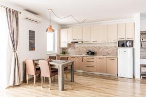 a kitchen with white cabinets and a table and chairs at Cityapp in Sibiu