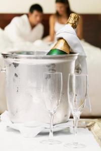 a bottle of champagne in a bucket with two wine glasses at Imperia Hotel & Suites Saint-Eustache in Saint-Eustache