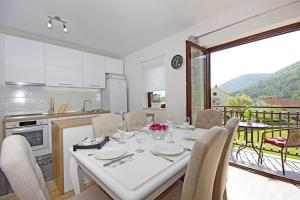 a kitchen and dining room with a white table and chairs at Lovely countryside Apartment Dolac - Valley, Vrlika in Vrlika