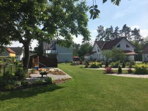 einen Hof mit Häusern, einem Baum und Gras in der Unterkunft Ferienhaus "GlückSEEligkeit" in Großkoschen