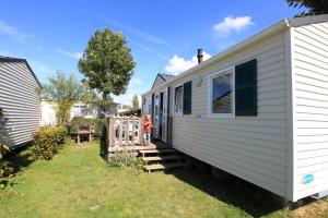 ein winziges Haus mit einer Person, die draußen steht in der Unterkunft Camping Les Vertes Feuilles in Quend