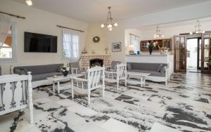 a living room with white furniture and a fireplace at Hotel Sphinx in Naxos Chora