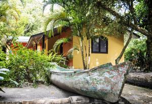 a boat sitting in front of a house at Pousada e Restaurante Fim da Trilha in Ilha do Mel