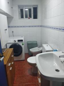 a bathroom with a washing machine and a toilet and a sink at O Pazo in O Grove