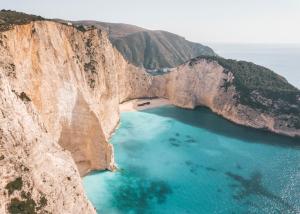 an aerial view of a mountain cliff with blue water at Villa Margarita in Anafonítria