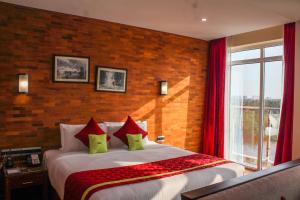 a bedroom with a large bed with red curtains at JVK Park Hotel in Cochin