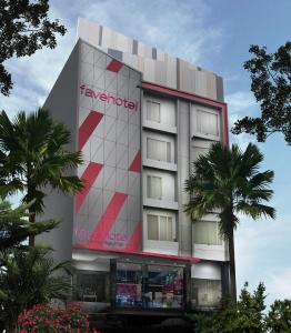 a building with a tamarind hotel with palm trees at favehotel Graha Agung Surabaya in Surabaya