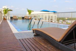 einen Pool mit einer Chaiselongue auf dem Balkon in der Unterkunft JVK Park Hotel in Kochi