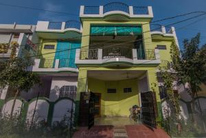 a yellow and white building with a balcony at Sanctuary Tourist Lodge in Bharatpur