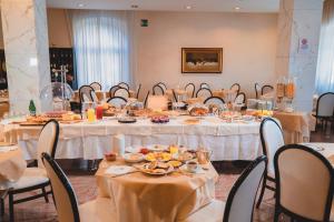 a dining room with tables and chairs with food on them at Grand Hotel Milano in Chianciano Terme