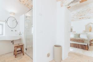 a white bathroom with a shower and a sink at Borgo Canonica in Cisternino