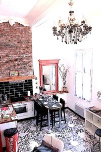 a kitchen with a dining room table and a chandelier at Le Duplex du Mole in Sète