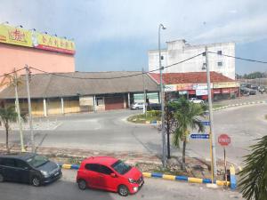 two cars parked in a parking lot next to a street at Harbour View Hotel Sekinchan in Sekinchan