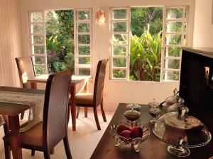 uma sala de jantar com mesa, cadeiras e janelas em Hotel Curitiba Campo Comprido em Curitiba