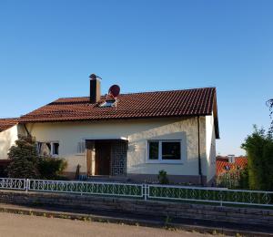 ein kleines weißes Haus mit einem roten Dach in der Unterkunft Ferien in Neuffen - Ferienwohnung Plaue in Neuffen
