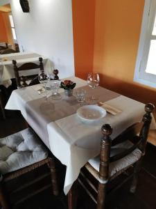 a table with a white table cloth and wine glasses at Fattoria del pino in Miasino