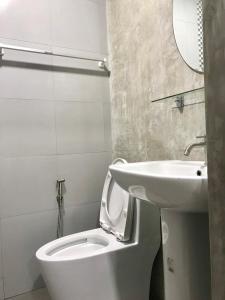 a bathroom with a white toilet and a sink at Easy Loft Hostel in Phuket