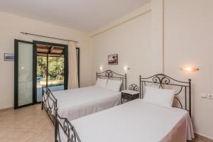 two beds in a room with a balcony at Giovanna Studios in Keri